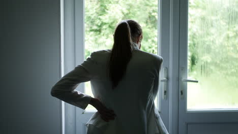 A-silhouette-of-a-pensive-woman-looking-out-of-a-window-stressed