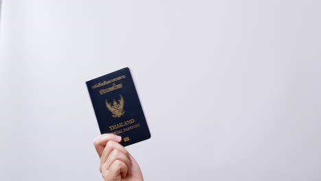 Woman's-hand-shows-the-Thailand-Passport-ready-for-travel-in-white-studio-background-with-copy-space
