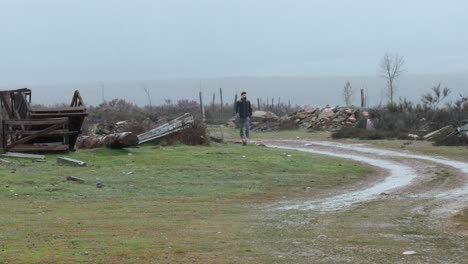 Solitary-man-walk-towards-camera-on-a-devastated-place