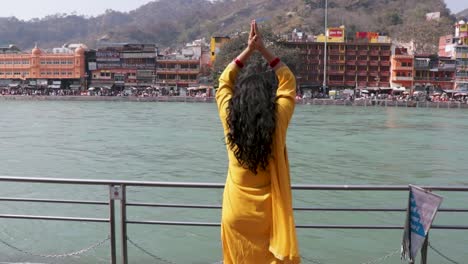 isolated-young-girl-prying-the-holy-ganges-river-at-river-bank-from-flat-angle-video-is-taken-at-ganga-river-bank-haridwar-uttrakhand-india