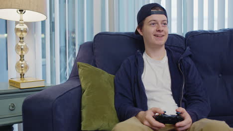 Young-man-plays-video-games-happily-and-looks-to-the-side