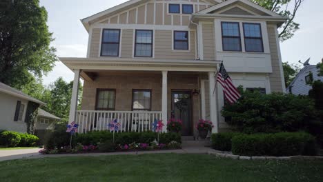 Push-towards-nice-house-in-the-suburbs-and-a-patriotic-spinner-decorating-the-front-porch