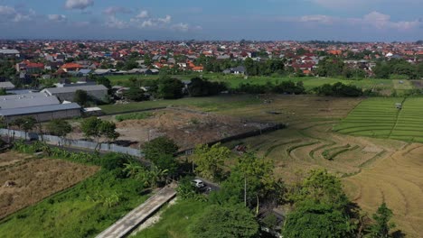 Luftaufnahme-Von-Autos-Und-Motorrädern,-Die-Nach-Einer-Ernte-In-Bali,-Indonesien,-An-Verbrannten-Reisfeldern-Vorbeifahren