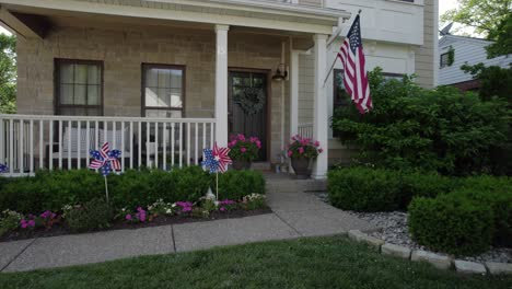Camera-drifts-in-front-of-a-nice-suburban-house-with-an-American-flag-and-patriotic-decorations