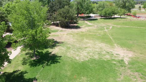 A-rising-drone-shot-of-a-flag-marker-placed-on-the-lawn-of-a-public-park