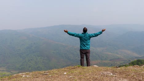 Ein-Mann,-Der-Allein-Auf-Einem-Hügel-Mit-Nebligem-Gebirgshintergrund-Aus-Einem-Flachen-Winkelvideo-Geht,-Wird-In-Nongjrong-Meghalaya,-Indien,-Aufgenommen