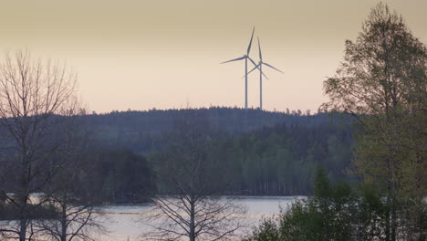 Goldene-Stunde---Windturbinen-Drehen-Sich-über-Einem-Wald-Und-Einem-See-In-Schweden