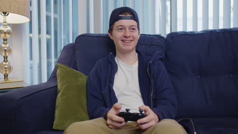 Young-man-smiles-and-celebrates-while-playing-video-game