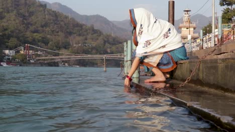 isolated-young-indian-girl-praying-at-ganges-river-bank-from-different-angle-video-is-taken-at-ganga-river-bank-rishikesh-uttrakhand-india