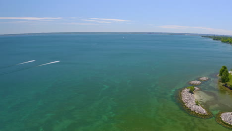 Aerial-view-of-two-personal-water-crafts-in-the-distance-riding-across-the-lake-on-a-summer-day