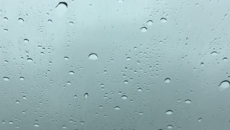 Rain-drops-flowing-on-a-driving-car's-windshield