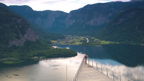 Cinematic-tracking-shot-of-a-girl-and-a-dog-on-Hallstatt-Skywalk