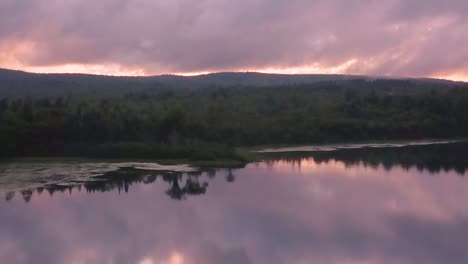 DRONE-DOLLY-ZOOM-into-cove-of-Monson-Pond,-Maine,-at-sunset
