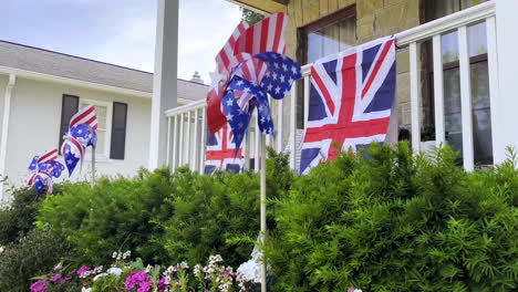 Closeup-on-patriotic-lawn-ornament-spinning-in-the-front-yard-of-a-house-with-British-flags-hanging-on-the-porch