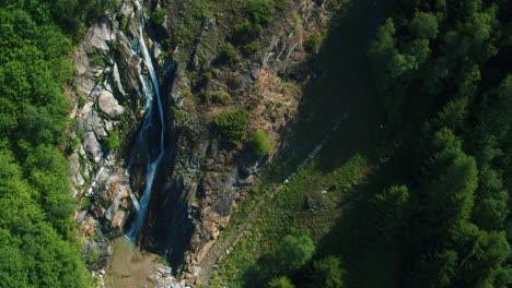 Filmische-Fallende-Luftaufnahme-Eines-Kleinen-Wasserfalls-In-Der-Schweiz