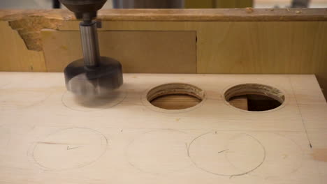 Close-up-clip-of-a-drill-press-in-the-process-of-drilling-a-hole-in-a-small-sheet-of-plywood