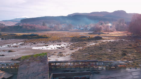Cinematic-aerial-reveal-shot-of-wrecked-boats-on-the-shore-on-Mull,-Scotland