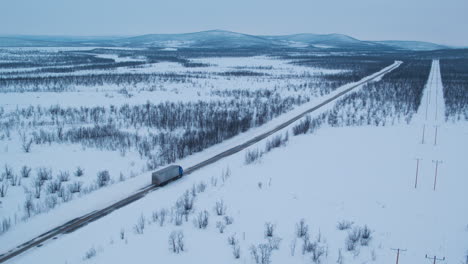 Cinematic-aerial-shot-of-a-truck-travelling-through-a-frozen-landscape