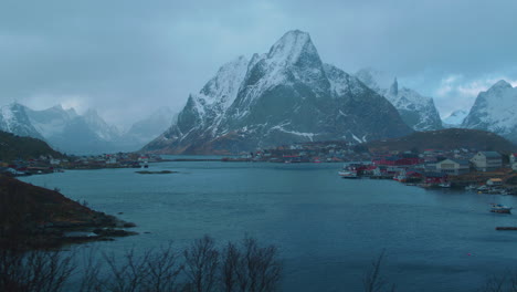 Stunning-cinematic-tracking-shot-of-Reine,-Lofoten,-as-snow-falls-from-the-sky