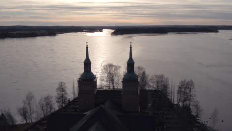 Stunning-cinematic-aerial-shot-passing-over-a-church-in-Sastamala,-Finland