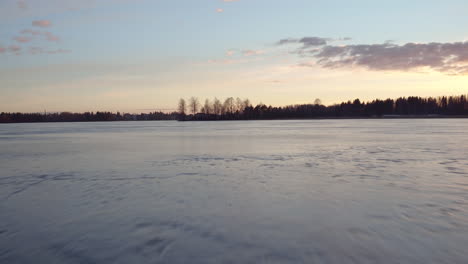 Stunning-cinematic-fast,-low,-dynamic-shot-flying-over-a-frozen-lake