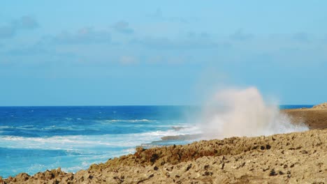 Waves-crashing-on-coral-coast-and-sending-misty-spray-high-into-air