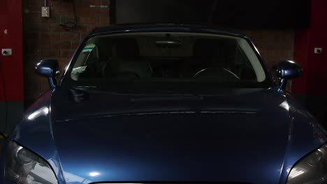 A-frontal-shot-of-a-blue-Audi-TT-in-a-garage