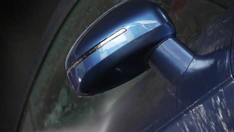 Detail-of-the-mirror-of-a-blue-Audi-TT-being-washed-with-high-pressure-water