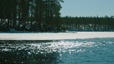 Cinematic-ice-cold-stream,-frozen-lake-track-and-panning-shot