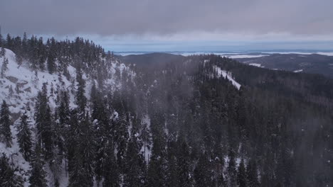 Atemberaubende-Filmische-Luftaufnahme-Eines-Nebligen-Schneebedeckten-Berges