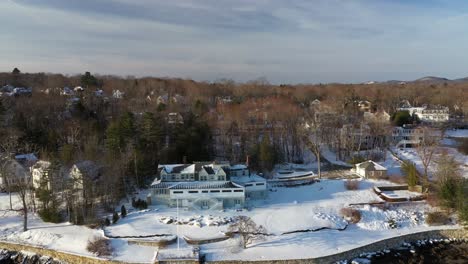Aerial-SLIDE-to-the-left-along-the-wintery-shore-of-Camden-Harbor