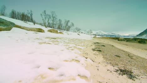 Cinematic-tracking-shot-left-to-right-of-a-frozen-beach-in-Norway