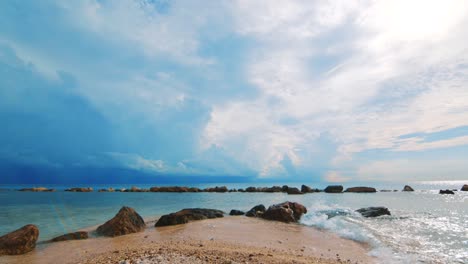 Slowmo-gentle-waves-breaking-on-sandy-Caribbean-beach-with-storm-clouds-behind