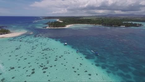 Korallenriffe-Der-Insel-Mit-Einem-Schnellboot,-Das-Sich-über-Das-Kristallklare-Wasser-Des-Ozeans-Der-Inselinsel-In-Mauritius-Bewegt