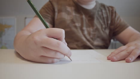 Un-Niño-Escribiendo-En-Papel-Con-Un-Lápiz
