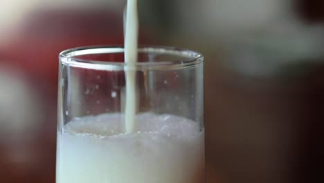 Milk-getting-poured-in-glass,-closeup-shot