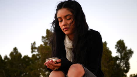 An-attractive-black-haired-girl-sitting-with-a-vintage-silver-jewelry-box-while-looking-sad-and-longing-on-an-autumn-day