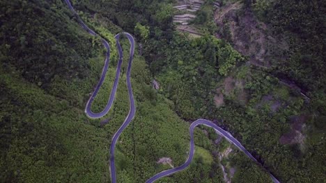 Moody-aerial-shot-of-a-curvy-road-in-a-mountainous-area-on-a-gloomy-day