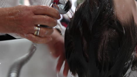 Close-up-of-a-hairdresser's-hands-washing-a-customers-hair-before-he-is-getting-a-haircut