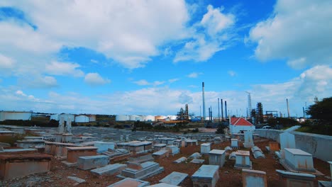 Zeitraffer-Eines-Leeren-Friedhofs-Mit-Einer-Großen-Industriellen-Raffinerie-Im-Hintergrund