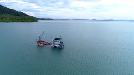 Halb-Versunkenes-Fischerboot-Am-Ufer-Einer-Einsamen-Insel-Umkreist-Drohne