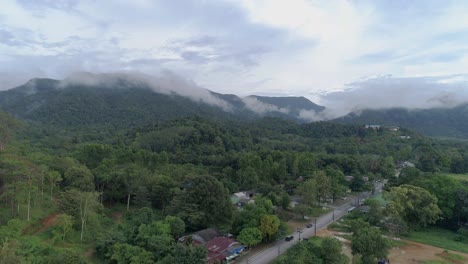 Ascending-drone-shot-of-green-lush-mountains-with-clouds-on-top