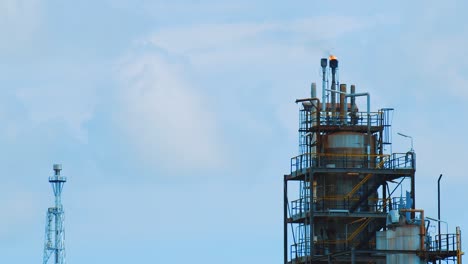 Zeitlupenaufnahme-Einer-Großen-Industriellen-Raffinerie-Mit-Feuer-Und-Schwarzem,-Umweltschädlichem-Smog,-Der-Von-Oben-In-Einen-Klaren-Blauen-Himmel-In-Curacao-Strömt
