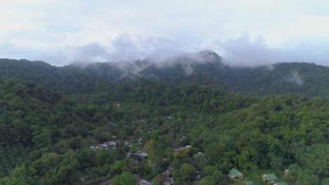 Slow-moving-drone-shot-of-green-mountains-with-clouds-covering-the-top