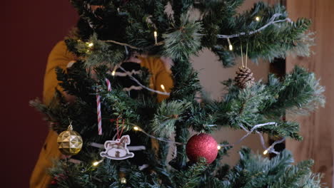 Mujer-Hermosa-Joven-Instalando-Un-árbol-De-Navidad-Con-Adornos-Y-Luces-Inclinándose-Hacia-Arriba