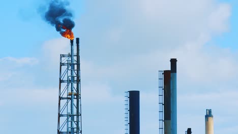 Spitze-Einer-Industriellen-Raffinerie,-Die-Umweltschädlichen-Schwarzen-Smog-In-Einen-Klaren-Blauen-Himmel-Im-Schönen-Curacao-Emittiert