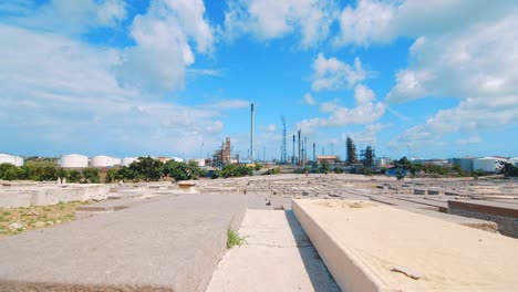 Low-angle-shot-from-within-an-empty-cemetery-in-Curacao-showing-a-large-industrial-refinery-in-the-distance