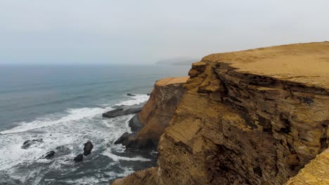 Aerial-shot-of-flying-over-the-edge-of-the-coast-line-at-the-Paracas-National-Park