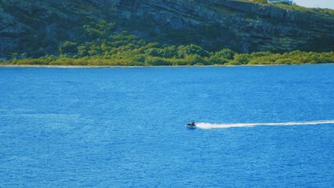 Slow-motion-shot-of-jet-ski-racing-across-a-large-lake-on-a-beautiful-sunny-day-in-Curacao