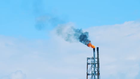 Schwarzer,-Umweltschädlicher-Smog,-Der-Von-Der-Spitze-Einer-Industriellen-Raffinerie-In-Einen-Wunderschönen,-Klaren-Blauen-Himmel-In-Curacao-Strömt